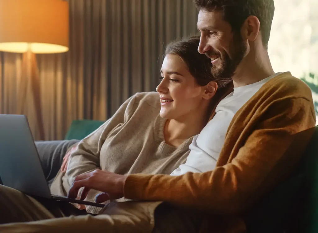 cozy couple on couch while on laptop