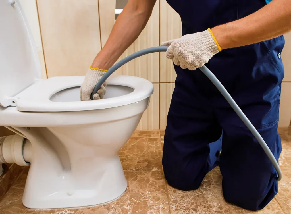 a plumber hydro jetting a toilet as part of sewer line maintenance springfield il