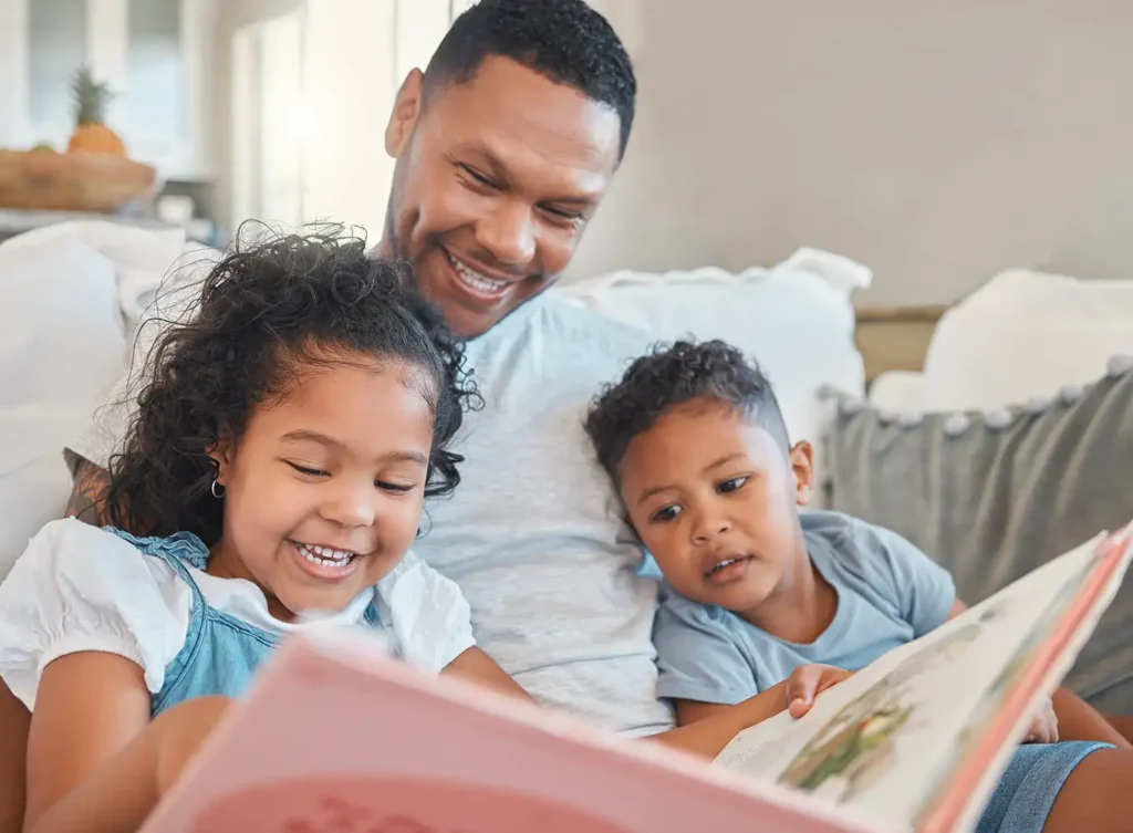 father reading a book to his two kids