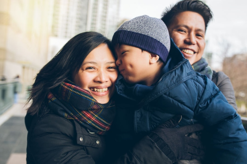 Is Your Heating System Ready for This Winter? Family snuggling together in warm winter clothing.