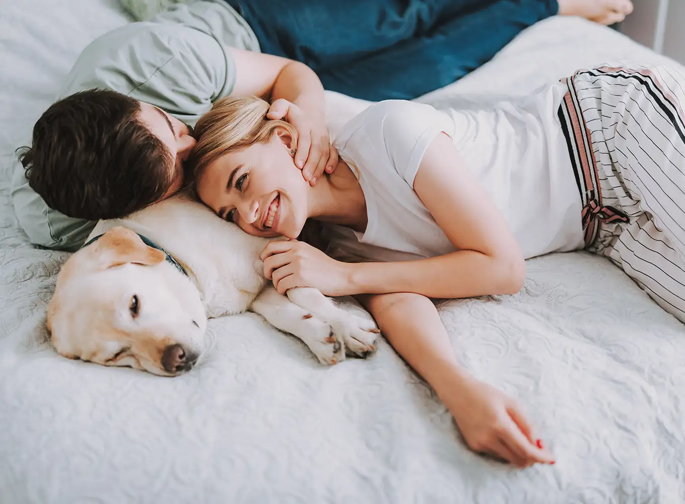 a couple and their Labrador Retriever cozy in their bed while enjoying their heated home auburn illinois
