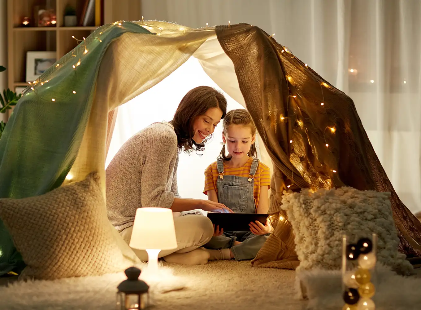 mother reading a bedtime story to daughter under a lit-up tent riverton il