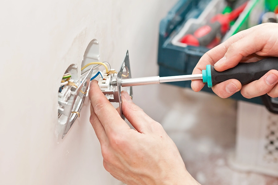 MB Heating & Cooling, Plumbing & Electric - Electrician using tools to install an outlet in the home of a Springfield, IL resident.