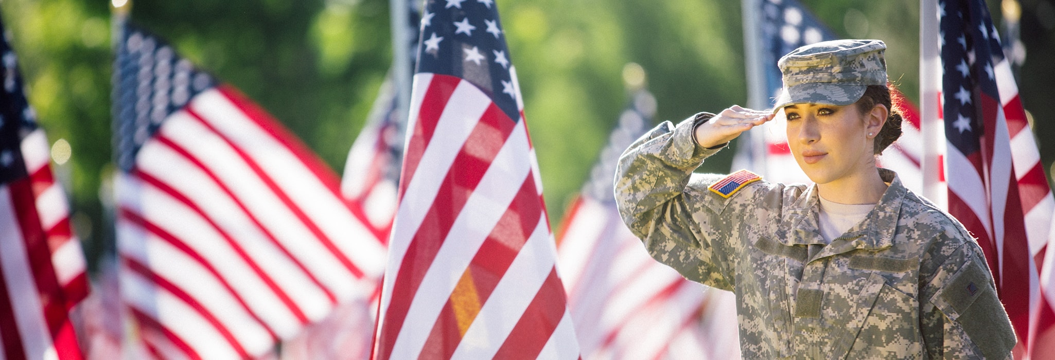 American Soldier saluting in front of flags